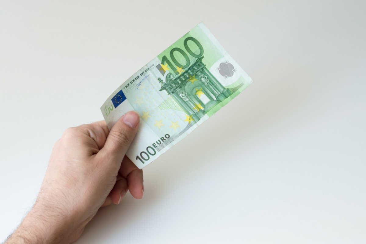 Hand gibt 100-Euro-Banknote