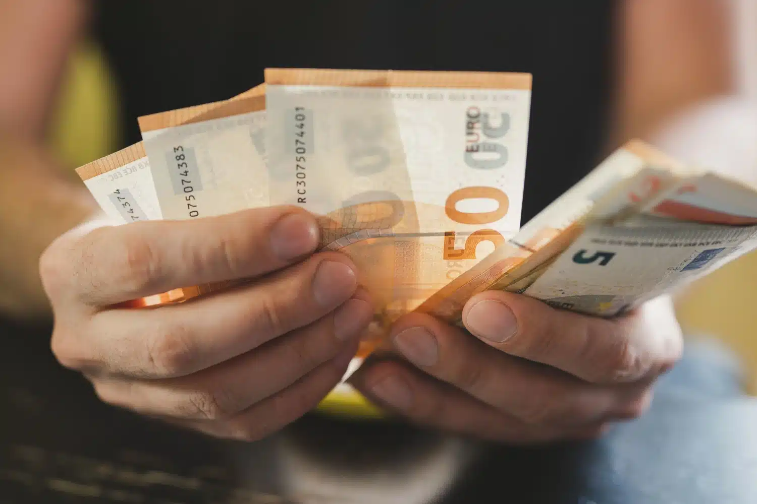 Hände zählen Geldscheine, symbolisch für Grundeinkommen