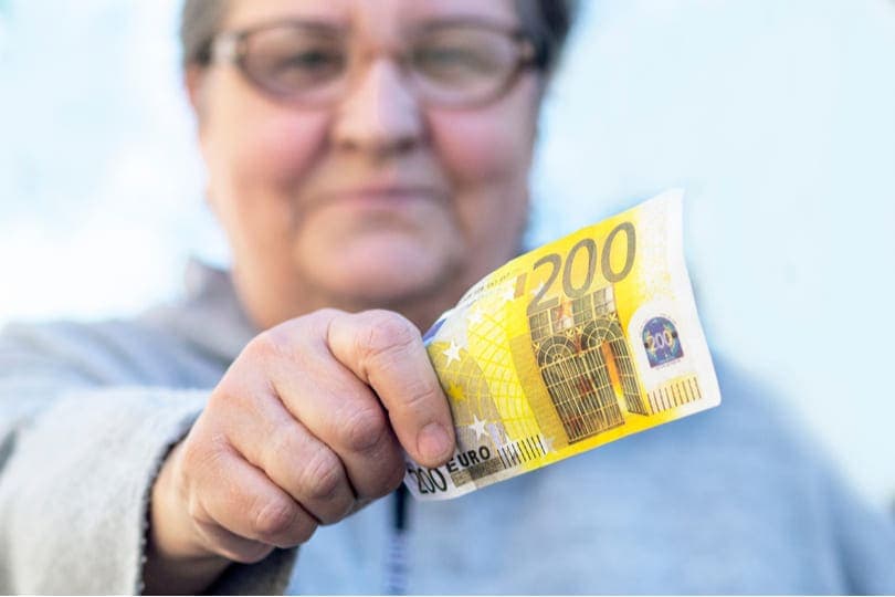 Frau hält 200 Euro in der Hand