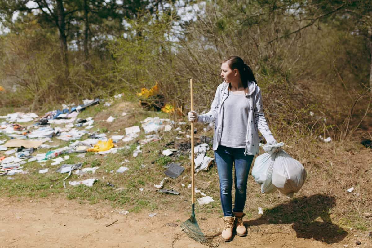 Junge Frau beseitigt Müll in Parkanlage