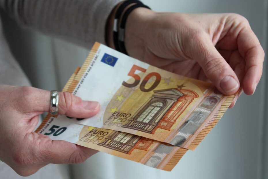 Hände halten 50 Euro Scheine in der Hand als Symbol für einen Bonus beim Bürgergeld