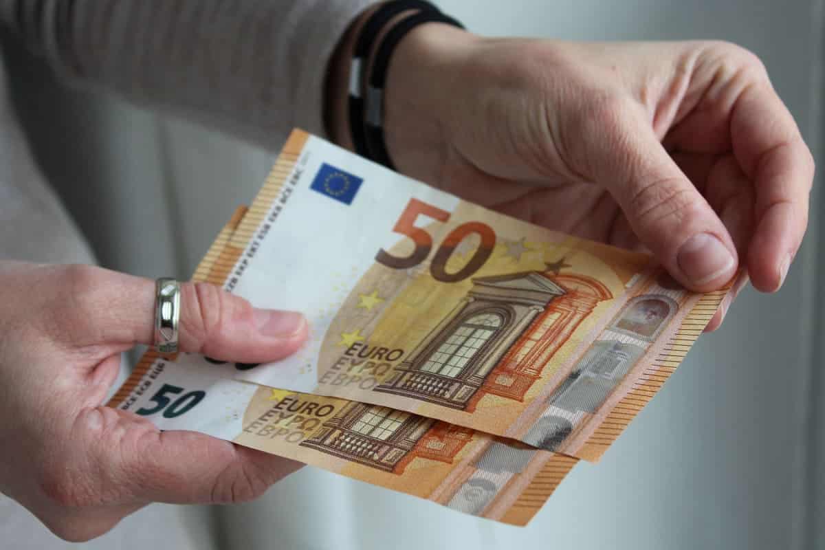 Hände halten 50 Euro Scheine in der Hand als Symbol für einen Bonus beim Bürgergeld