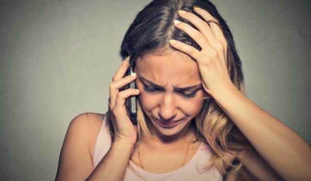 Verzweifelte Frau beim Telefonieren - Meldepflicht