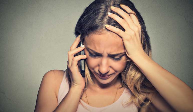 Verzweifelte Frau beim Telefonieren - Meldepflicht