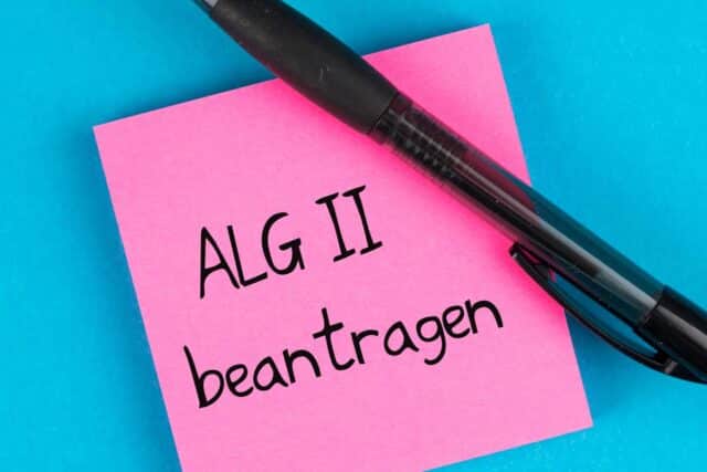 Rosa Zettel mit der Aufschrift ALG II beantragen