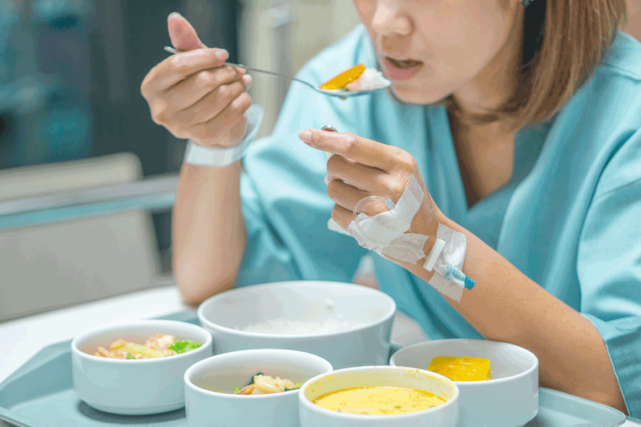 Frau isst im Krankenhausbett