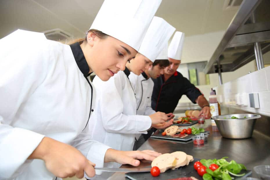 Koch in Ausbildung schneidet