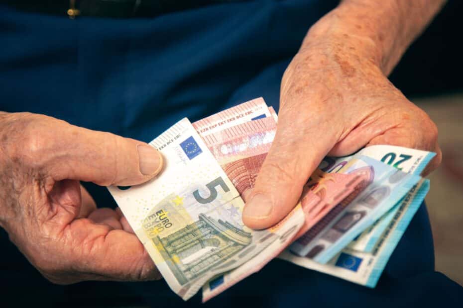 Rentnerhände zählen ein paar Euro-Geldscheine, Symbol für Altersarmut