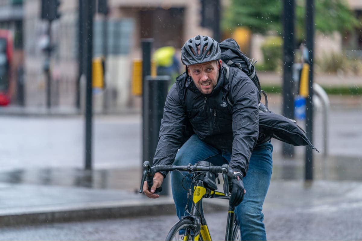 Mann auf Fahrrad im Regen