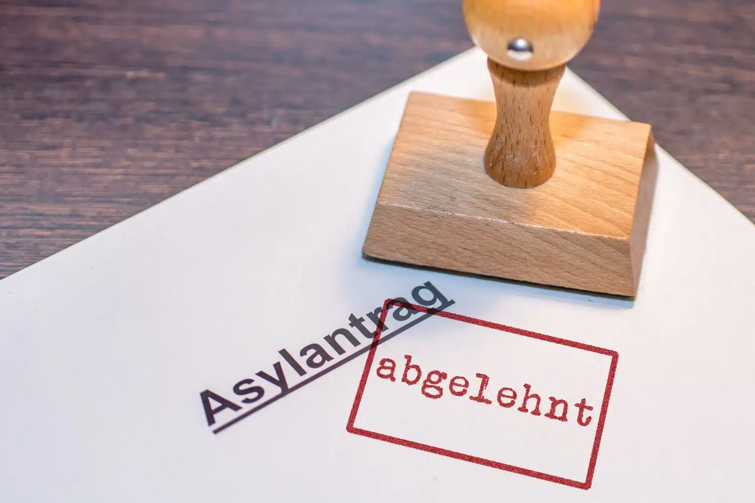 Symbolisch wird ein Asylantrag mit einem roten Stempel "abgelehnt" versehen