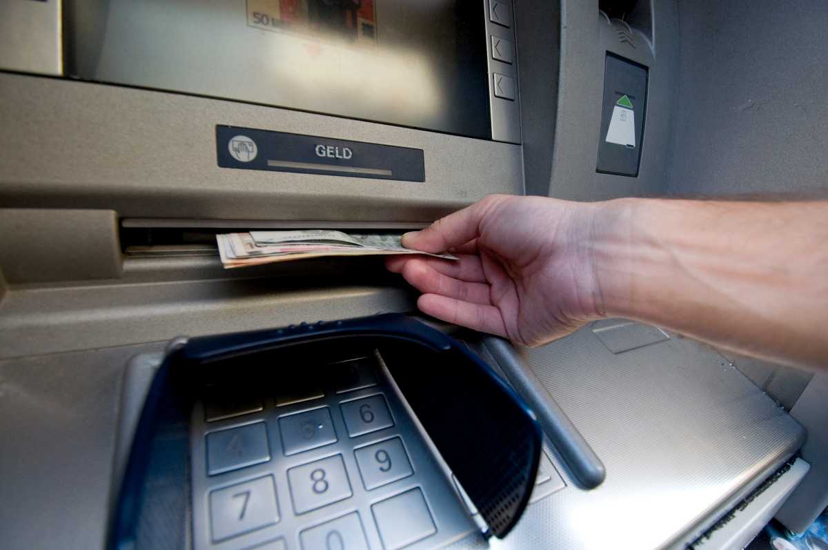 Person hebt Bargeld am Geldautomaten ab