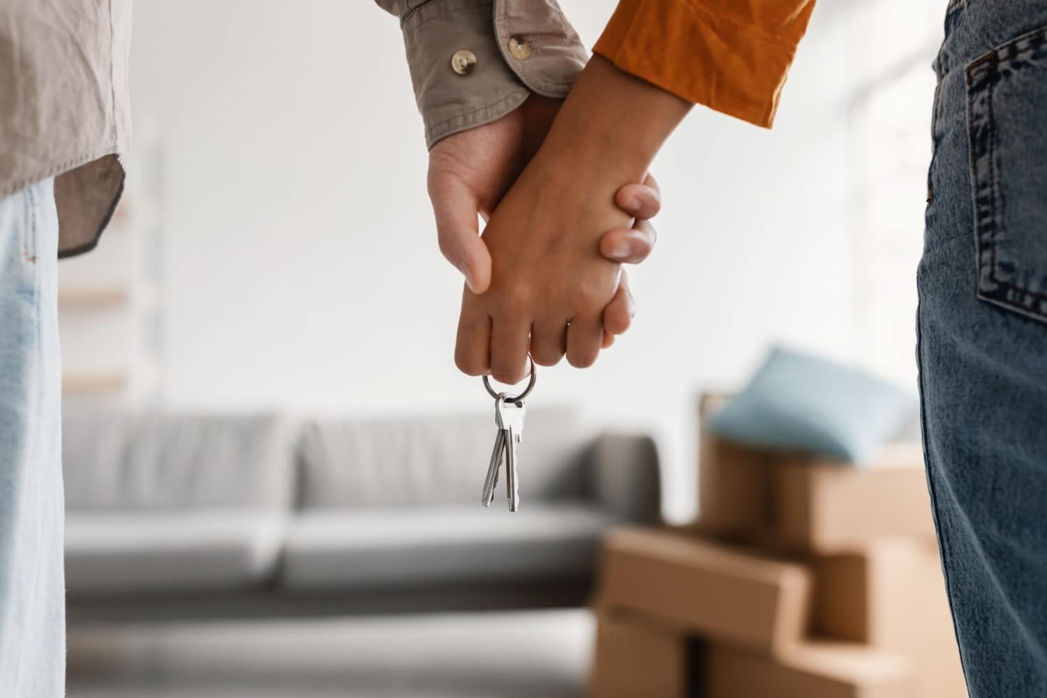 Mann und Frau halten gemeinsam Schlüssel für neue Wohnung in der Hand