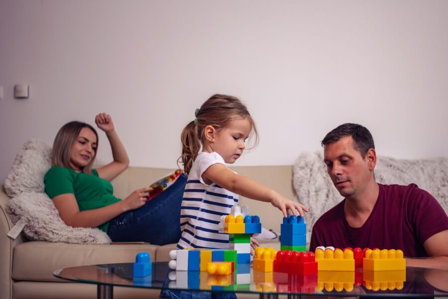 Mutter, Vater und Tochter spielen im Wohnzimmer