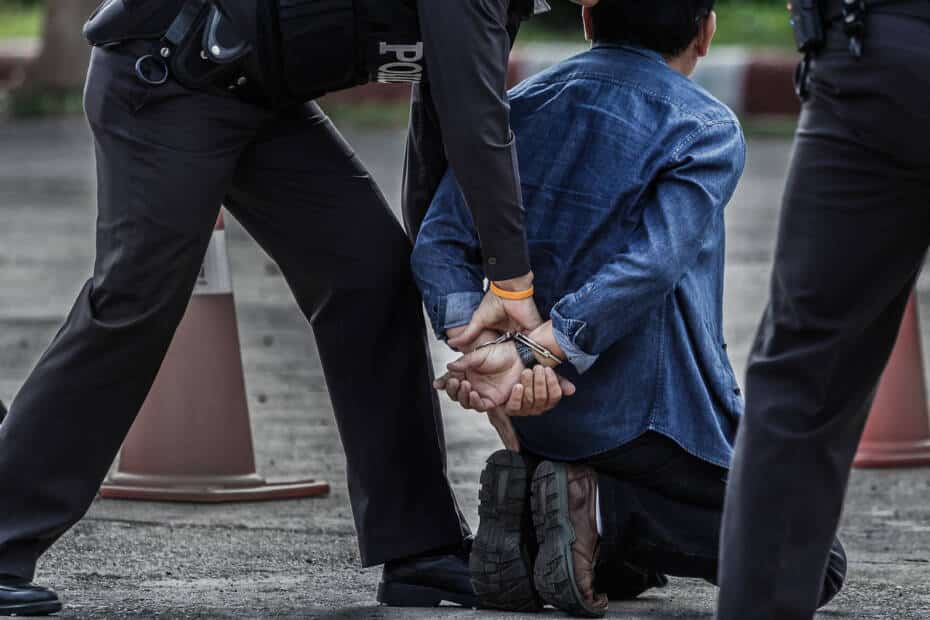 Mann in Handschellen mit 2 Polizisten