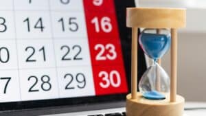 Sanduhr vor Tablet mit Kalender, symbolisch für fristgerechten Bürgergeld-Antrag