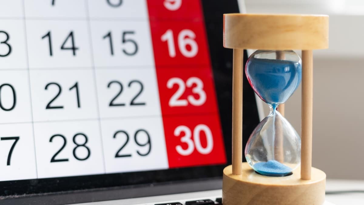 Sanduhr vor Tablet mit Kalender, symbolisch für fristgerechten Bürgergeld-Antrag