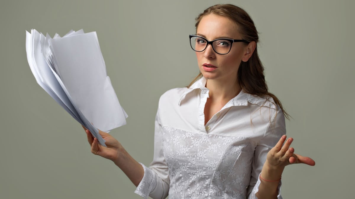 Frau hält frustriert Stapel Jobcenter Bescheide und Dokumente, symbolisiert Bürgergeld Widerspruchsfrist Verlängerung