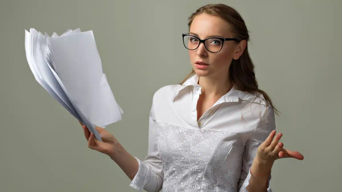 Frau hält frustriert Stapel Jobcenter Bescheide und Dokumente, symbolisiert Bürgergeld Widerspruchsfrist Verlängerung