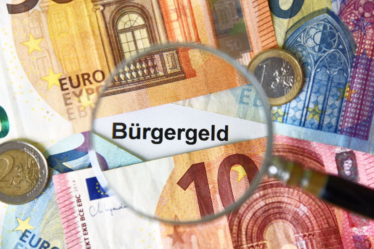 Bürgergeld unter der Lupe mit Euro Scheinen