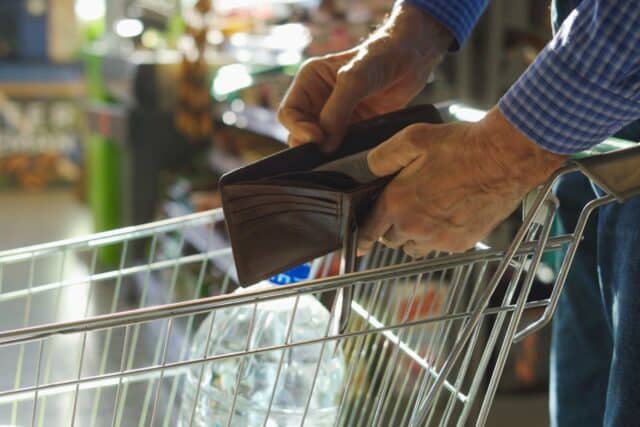 Offenes Portemonnaie über Einkaufswagen – Bürgergeld 2026, Nullrunde, Kaufkraft schrumpft.