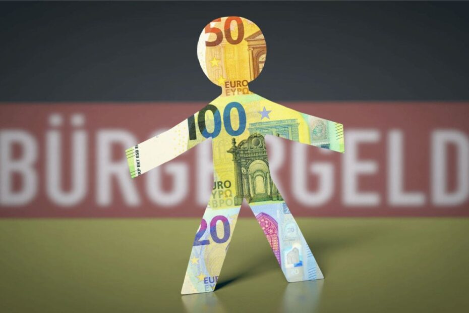 Papierfigur 100 Euro Schein vor Deutschlandflagge mit Bürgergeld Aufschrift