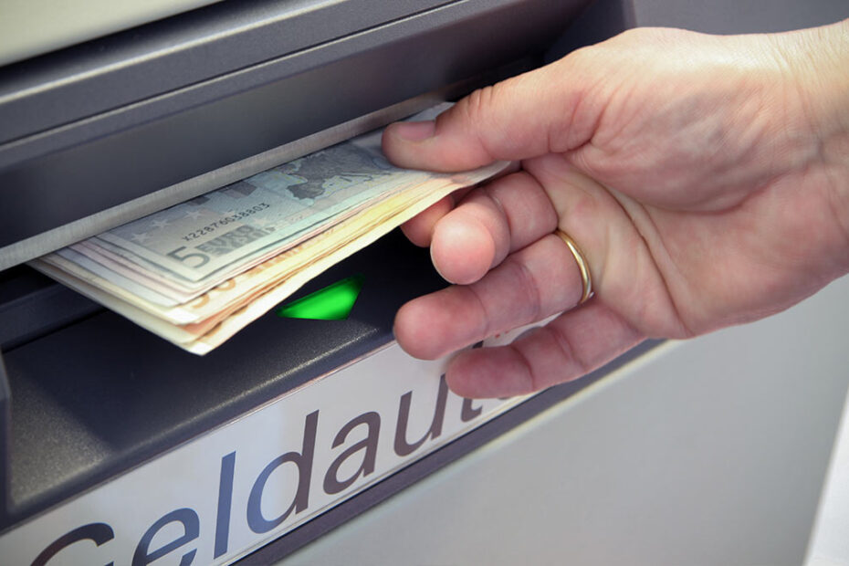 Hände machen heben Bargeld am Geldautomaten ab