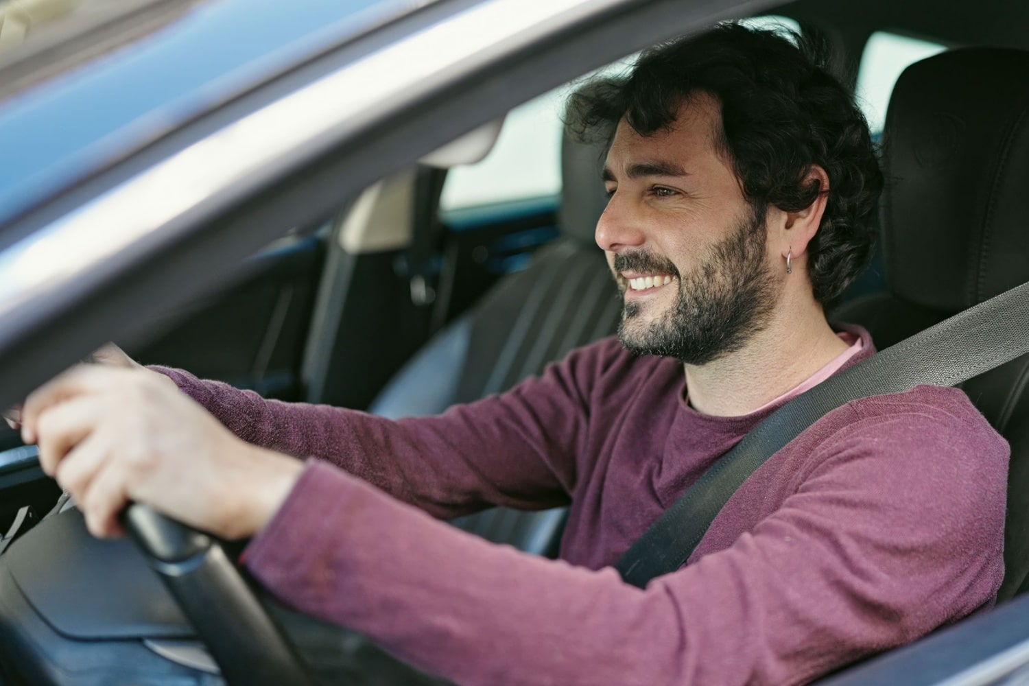 Junger Mann erfreut am Steuer eines Autos