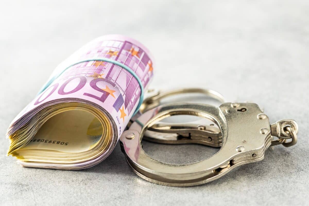 Euro-Geldbündel neben Handschellen, symbolisch für Bürgergeld Betrug