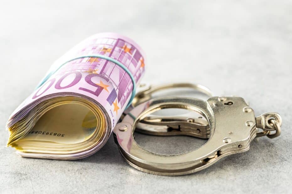 Euro-Geldbündel neben Handschellen, symbolisch für Bürgergeld Betrug