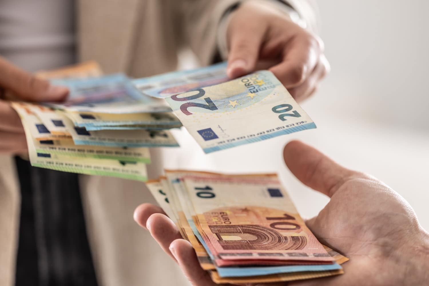 Geldübergabe mit Euro-Scheinen – Symbolbild für organisierten Bürgergeld-Betrug