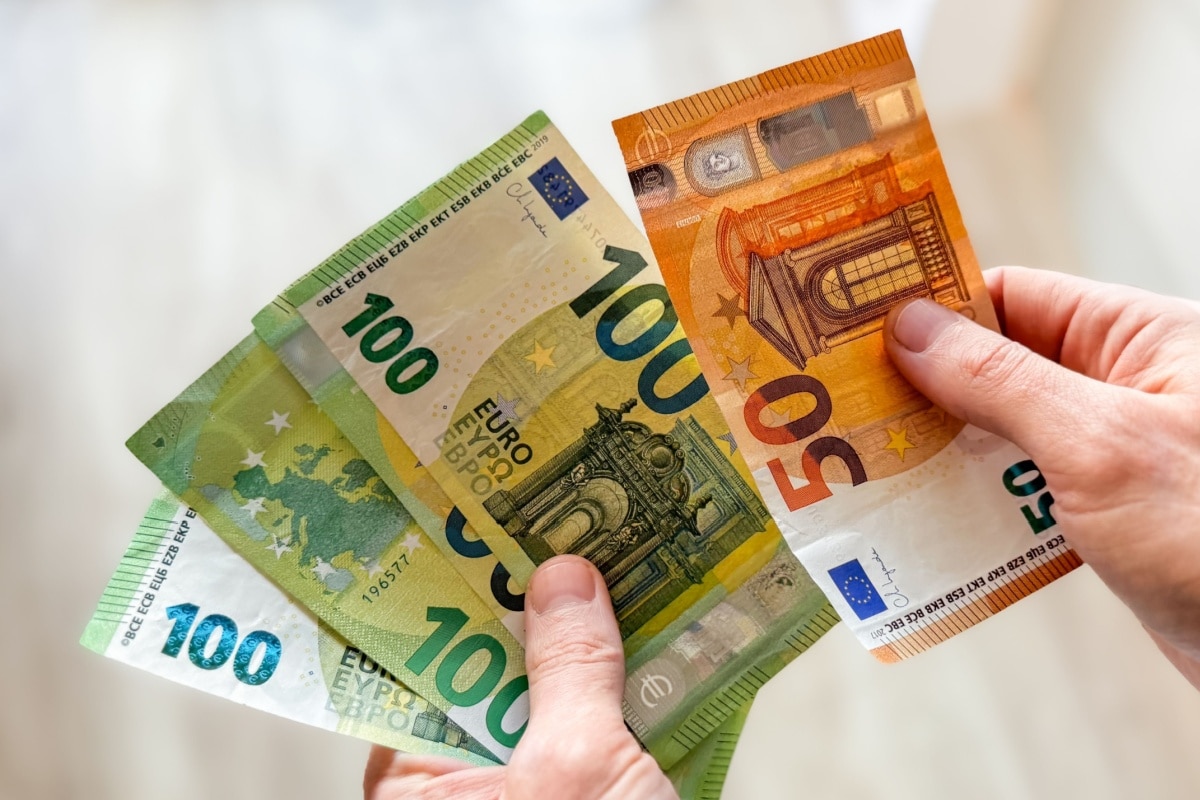 Hände halten Geldscheine, symbolisch für Bargeld