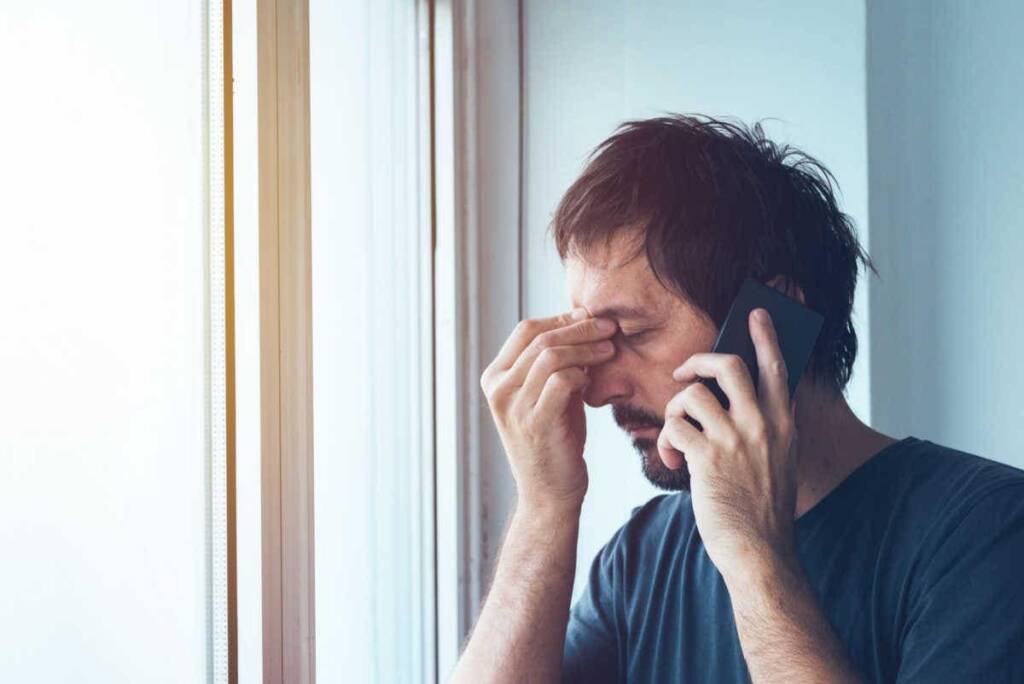 demotivierter Mann telefoniert