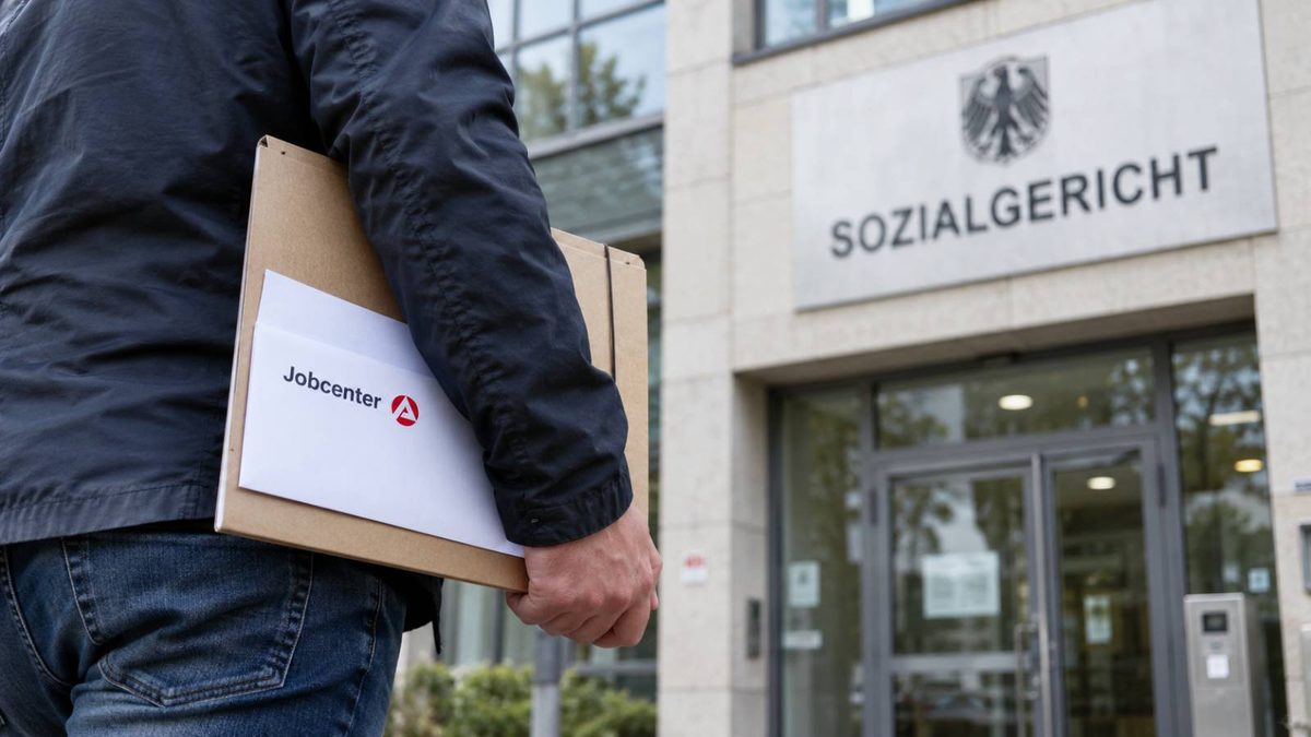 Mann mit Jobcenter-Unterlagen auf dem Weg zum Sozialgericht.