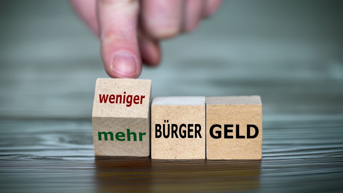 Holzwürfel mit Aufschrift Bürgergeld und mehr oder weniger