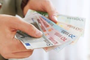 Nahaufnahme von Händen, die EUro-Geldscheine halten und zählen