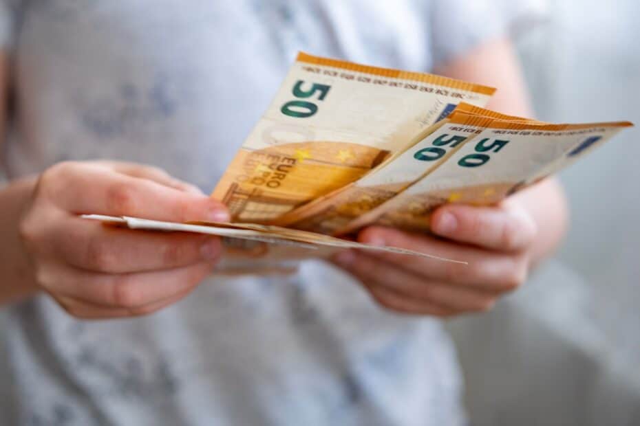 Hände zählen 50-Euro Scheine, symbolisch für Bürgergeld Höhe für Alleinstehende