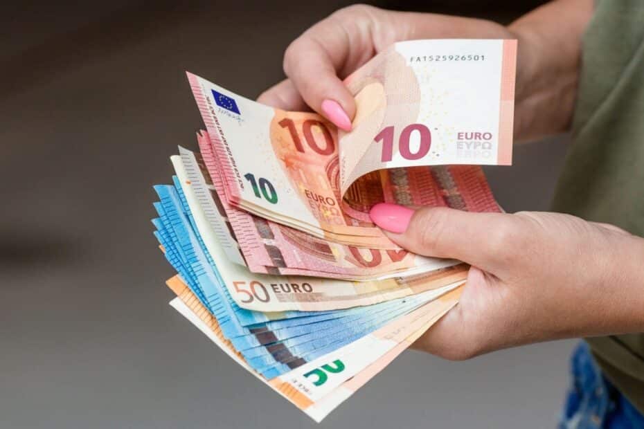 Frauenhände zählen Euro-Geldscheine, symbolisch für Bürgergeld Höhe für Alleinstehende