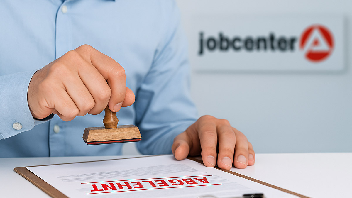 Ein Sachbearbeiter stempelt im Jobcenter ein Formular mit „ABGELEHNT“ – Symbolbild für abgelehnte Bürgergeld-Anträge.