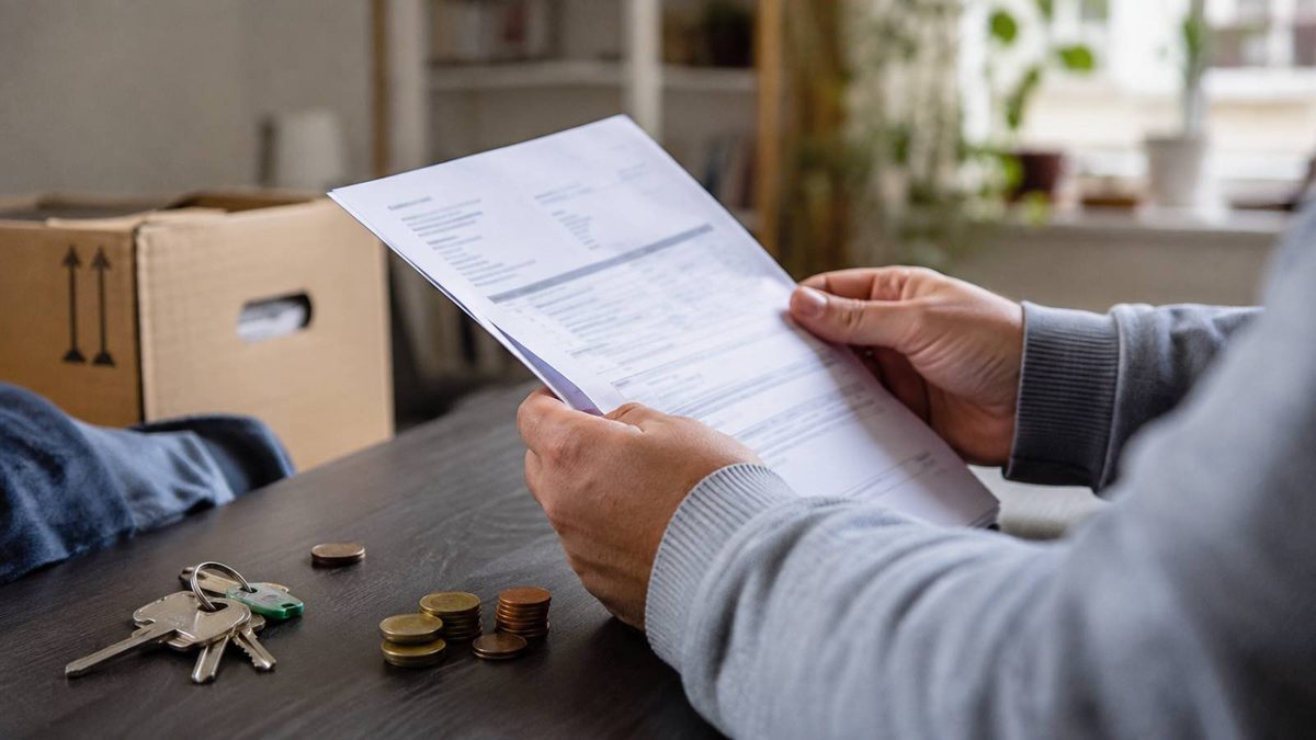 Leistungsempfänger prüft Rückforderungsbescheid neben Wohnungsschlüsseln und Münzen