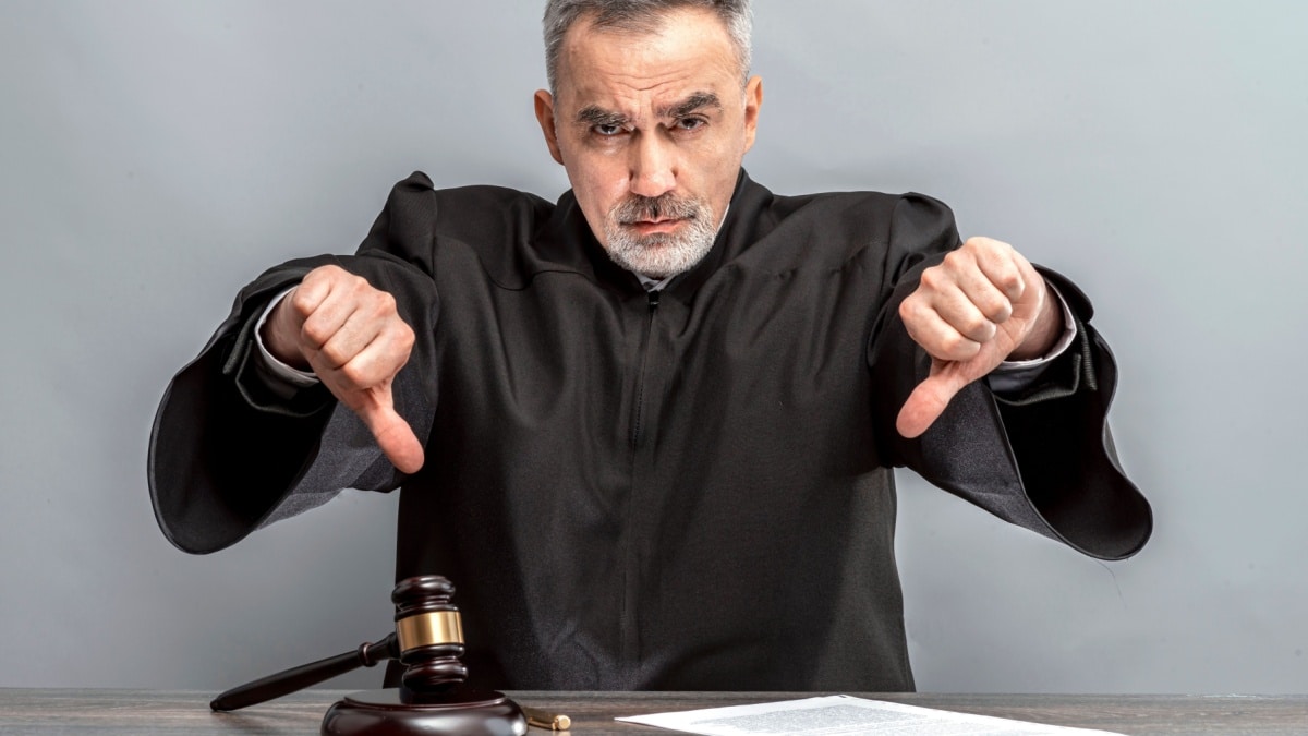 Symbolbild: Richter in Robe mit Daumen nach unten, was die ursprüngliche KdU-Ablehnung des Jobcenters symbolisiert.
