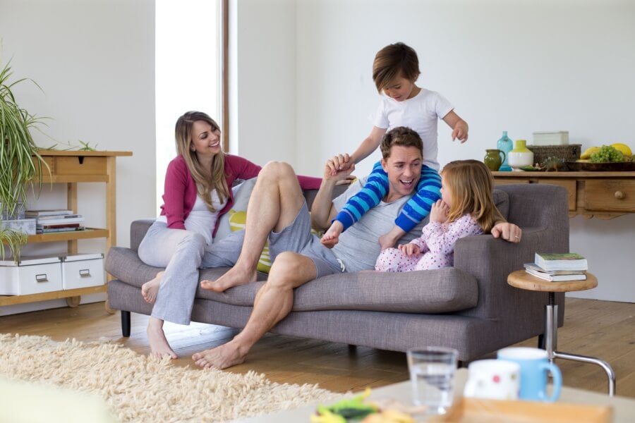 Familie mit Kindern auf dem Sofa im Wohnzimmer