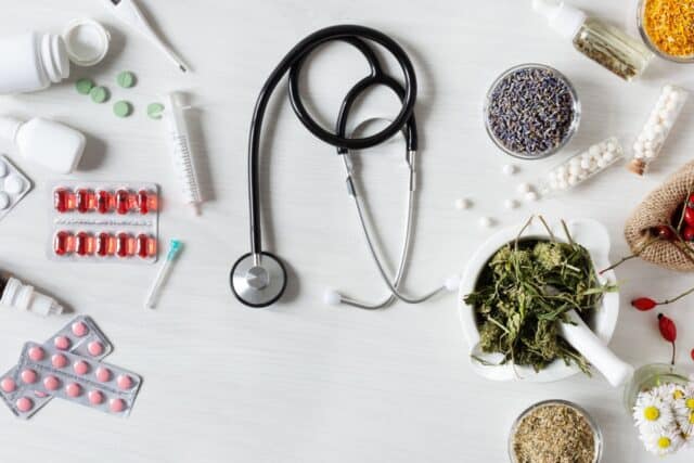 Traditionelle und alternative Medizin auf dem Tisch, in der Mitte ein Stethoskop