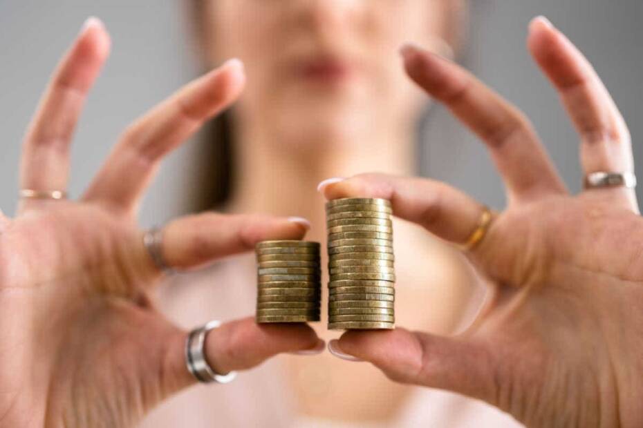 Frau mit unterschiedlich großen geldstapeln in der Hand