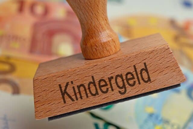 Stempel mit Aufschrift "Kindergeld" vor Geldscheinen