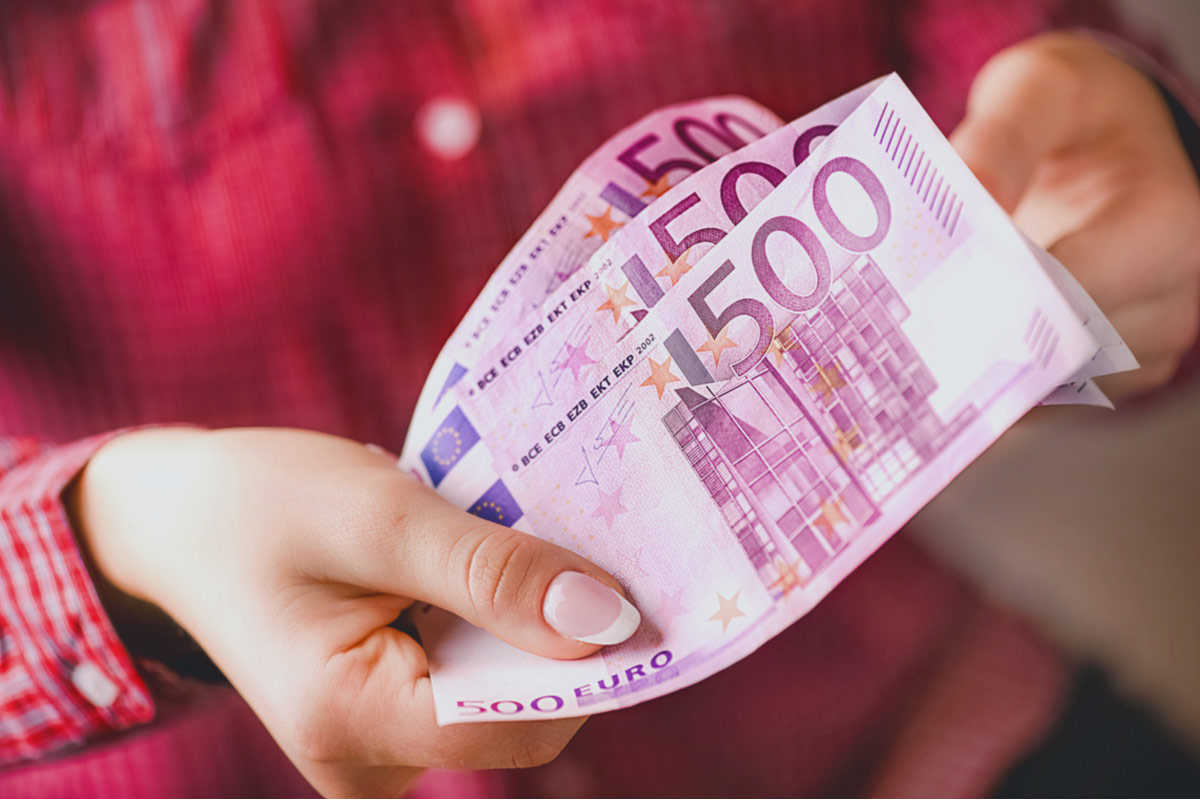 Frau hält 3 500 Euro Scheine in der Hand