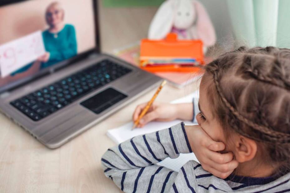 Kleines Mädchen sitzt vor einem Laptop