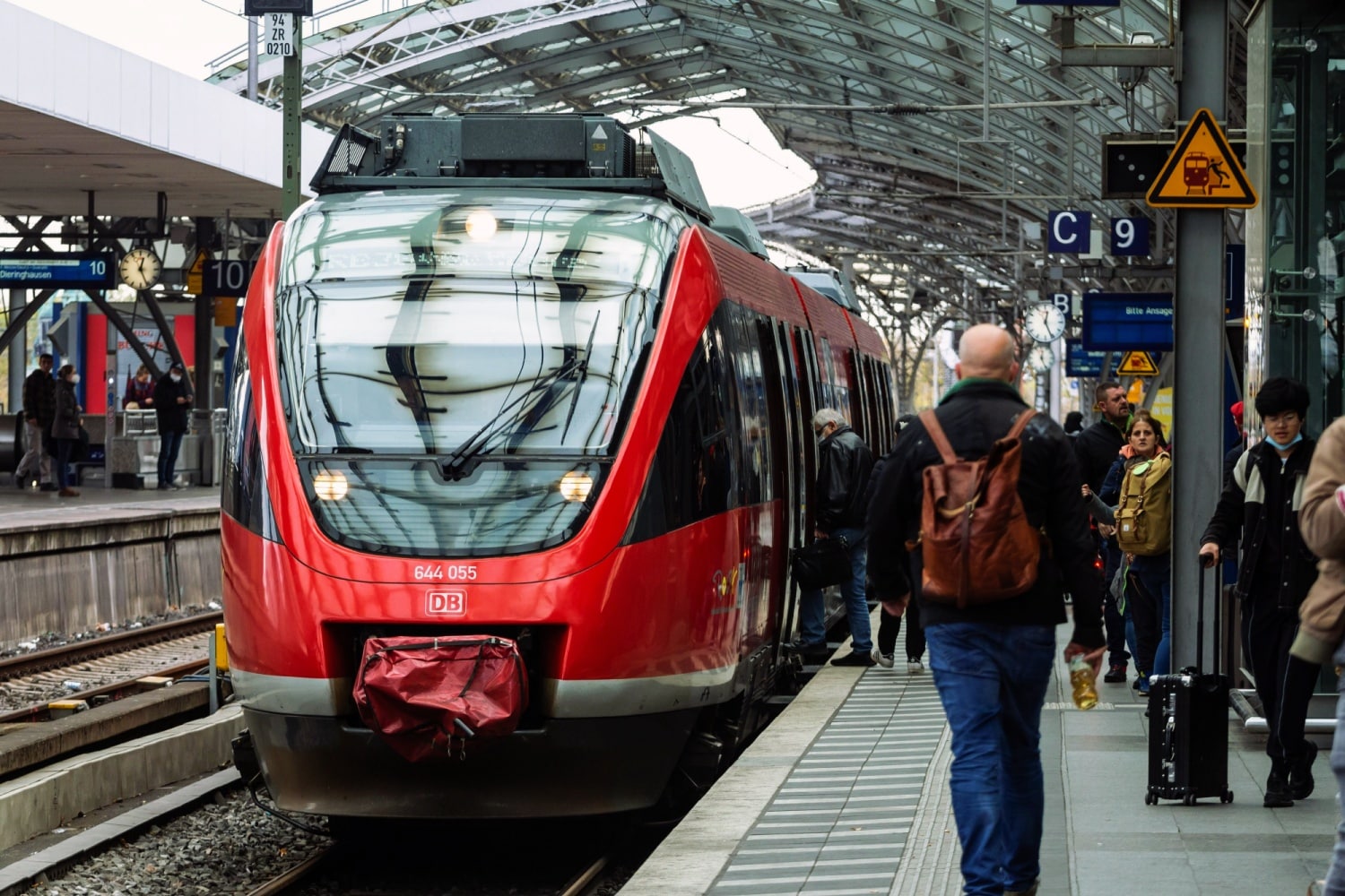 DB Regionalzug mit Fahrgästen am Bahnsteig im Banhof