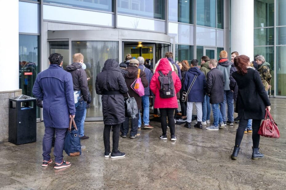 Menschenmenge versammelt vor einer Drehtür am Eingang