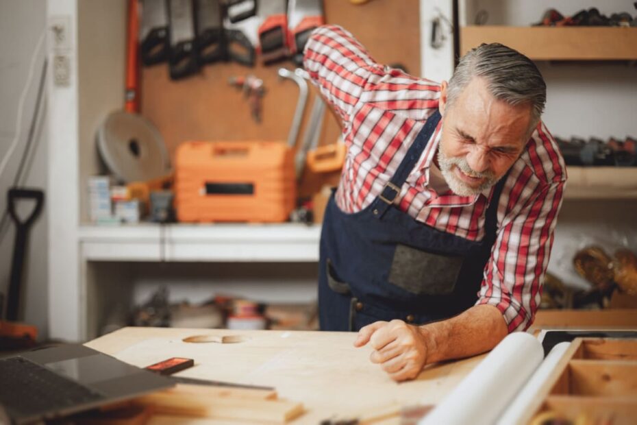 Älterer Mann bei der Arbeit mit Rückenschmerzen