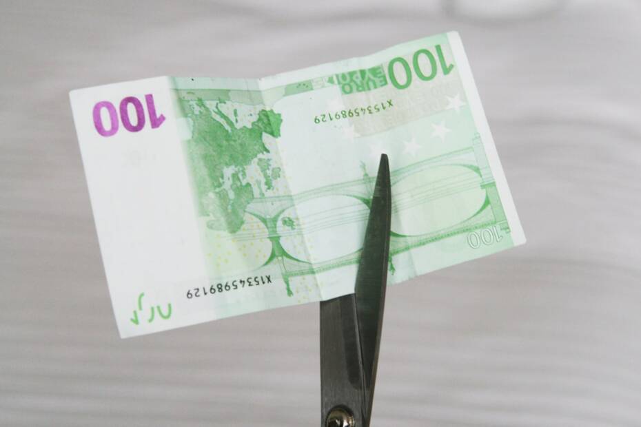 Geldschein 100 Euro mit Schere zerschneiden